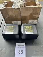 Two brand new PowerPro IP-L-M1435 power tool batteries placed in front of two open cardboard boxes.