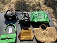 Six assorted purses on a black surface in outdoor lighting - front perspective showing all items