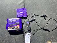 Roku Streaming Stick 4K device, remote control, power adapter, and original packaging laid out on black surface.