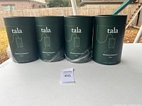 Four dark green cylindrical packaging tubes labeled 'tala Knuckle Pendant Walnut'.