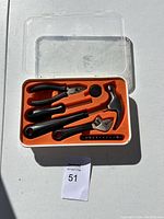 Mini hand tool set in plastic case, showing hammer, pliers, adjustable wrench, screwdriver handle and bits in orange interior.