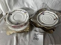 Six Royal Doulton bone china saucers with floral design, packaged and stacked on a soft white background, showing their new condition and packaging intact.