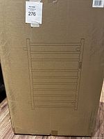 Cardboard box packaging showing line drawing of wall mount towel warmer with 8 bars, labeled with lot number.