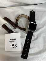 Fitbit Blaze watch face and brown leather straps laid out on fabric.