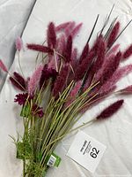 Multiple pink and burgundy fluffy artificial flower stems arranged on white background, showing overall lot condition and variety.