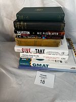 Photo showing eight books stacked, titles visible including 'Galveston' and 'Give and Take'. Various conditions with some yellowing and wear.