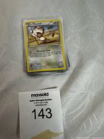 Top card clearly showing Meowth Pokémon card on a stack, with auction label in image