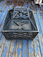 Overhead angle showing the fire pit's mesh screen, metal lattice sides, and included poker tool on lid.