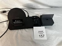 Front angle photo showing whole wireless charging station with phone charging pad, Apple Watch charger, and AirPods charging compartment along with attached USB cable.