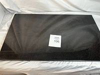 Full view of large rectangular black quartz cutting board with light speckles.