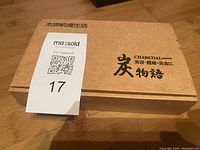 Closed wooden box container labeled with charcoal branding and maxsold tag