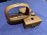 Wooden batten and shuttle placed on blue fabric showing detail of woodwork and metal parts on shuttle