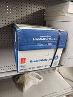 Box of Hammermill Great White 30 printer paper with branding and product details visible.