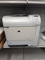 Front view of HP LaserJet P4014n printer showing the paper tray and output opening.