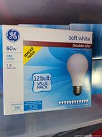 Front of a box of GE soft white 60 watt light bulbs showing brand, wattage, lumens, life expectancy, and pack quantity