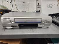 Front view of Panasonic VCR showing slot and buttons, silver casing