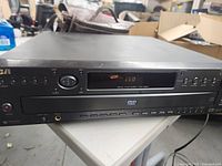 Front view of RCA multi DVD player showing disc tray, power button, disc select buttons, and LED display.
