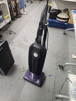 Full view of Riccar SupraLite upright vacuum cleaner showing handle, black fabric bag, and purple base.