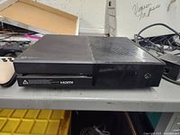 Photo of black Xbox One console with disc drive on a table
