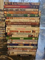 Stack of 20 DVD cases, mostly comedy films with visible titles including Starsky & Hutch, Don Omar, Due Date, Black Knight, Ted, Forrest Gump, and others.