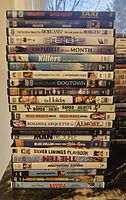 22 DVD movies in their cases stacked vertically with readable spines showing titles, mostly comedy genre.