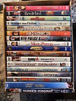 Photo of 19 DVDs including TV series and movies stacked in box