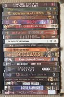 Stacked DVD cases mostly showing spines, Western movie titles visible