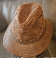 Front view of brown leather outback hat showing texture and shape.