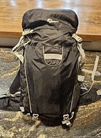 Front view of the black Lowepro camera backpack showing the main compartment, top flap, and external attachment straps.