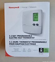 Photo of Honeywell programmable electric heat thermostat box showing product image and key features.
