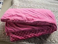 Folded pink weighted blanket showing the plush soft fabric side.
