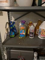 Shelving with various cleaning products including spray bottles and large jugs