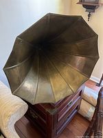 Large flared metal horn attached to wooden base