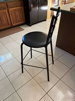 Side view showing metal frame, round padded seat, and three horizontal bars on backrest