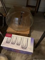 Clear glass punch bowl on top of box with boxed Cristal d'Arques Longchamp glasses underneath