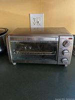 Front view of Black & Decker toaster oven showing glass door and metal exterior.
