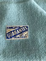 Close up of soft blue wool blanket showing label 'All Wool Guarantex only at Pontings.'