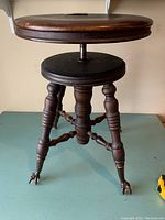 Front angle showing full piano stool with round seat and turned legs