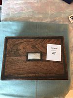 Top view of closed antique wooden writing box showing wood grain and mother of pearl inlay
