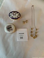 Photo of three decorative jewelry boxes, gold-tone teardrop earrings, and gold-tone necklace with citrine-like stones, arranged on white background with MaxSold tag