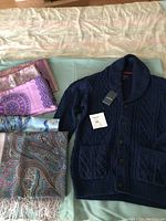 Photo showing blue Daniel Hechter cable knit cardigan with five paisley and floral scarves in pink, blue, purple, and earth tone colors.