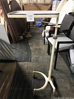 Full front view of enamel tray on adjustable stand with caster base