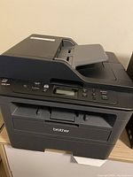 Front view of Brother DCP-L2550DW printer and photocopier showing paper input tray and control panel.