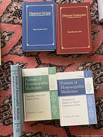 Photo of five homeopathy books: two hardcover books by Roger Morrison, M.D. in slipcases, and three softcover volumes by Catherine R. Coulter.