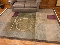 Full view of the area rug placed under a sofa showing size and design layout