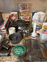 Overview of baking and kitchen tools including vintage pepper mill, cookie cutters, electric cutting tool, flour sifter, metal scale, and molds.