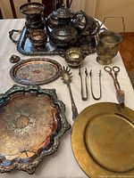Full overview showing all items including trays, tea pots, small bowls, utensils, and scissors laid out on a table.