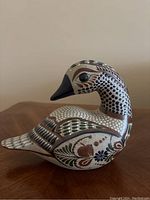 Side profile view of the hand painted pottery duck showcasing the detailed artistic patterns on the body and neck.