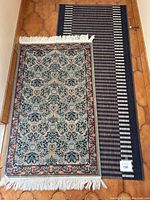 Pair of runners lying on a tiled floor, one traditional floral pattern and one striped.