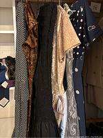 View of six summer dresses hanging in closet showing different patterns and fabrics